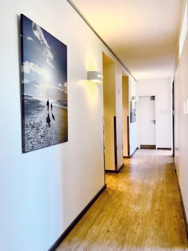 Praxisflur mit Wandbild und Behandlungsräumen.