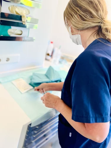 Praxisassistenz bereitet sterile Abdecktücher und Instrumente vor.